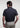 Man wearing the Square F performance polo by Ferret, featuring hidden placket and geometric F pattern for a refined golf look. Minimal design golf polo. Quality golf